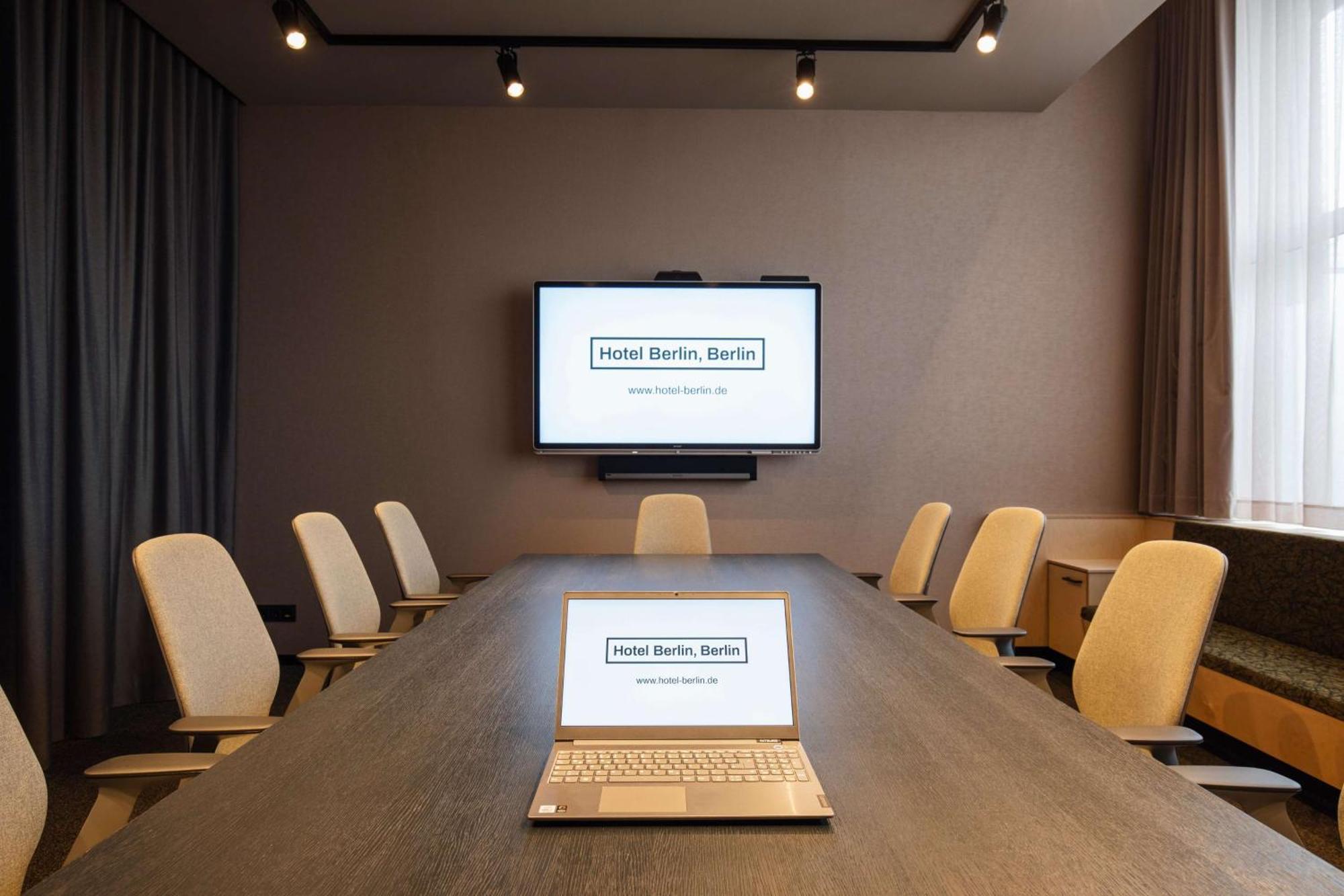 Hotel Berlin, Berlin, A Member Of Radisson Individuals Buitenkant foto The photo shows a modern conference room. In the center, there is a long table with a laptop open on it. Above the table, there is a large screen displaying "Hotel Berlin, Berlin" as well as a website address. The room is well-lit with spotlights and